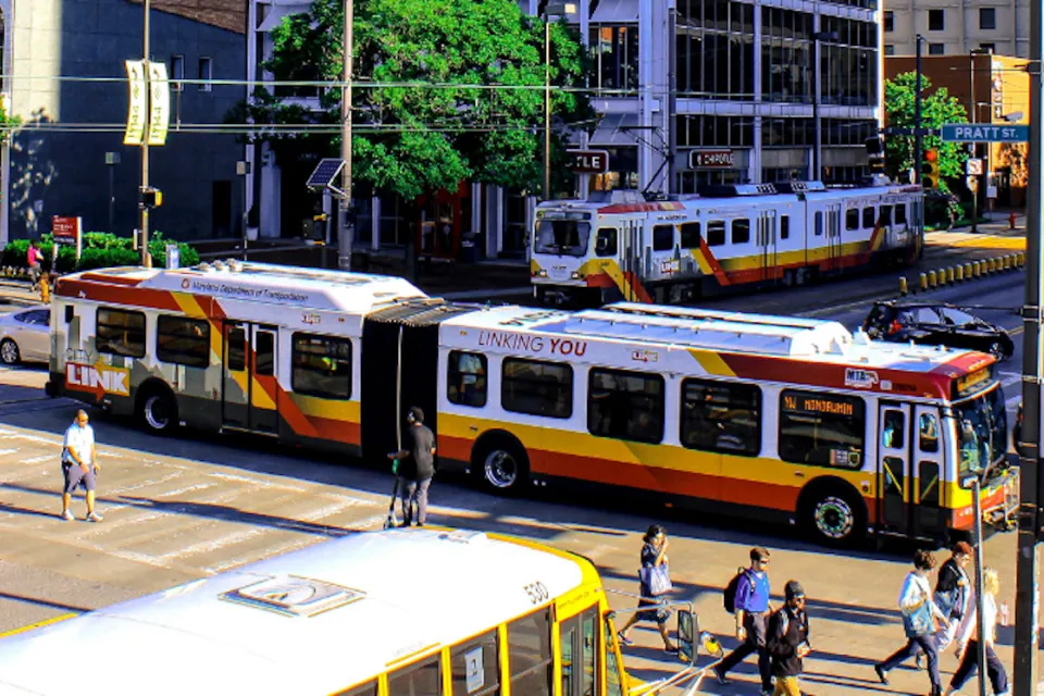 Buses and pedestrians on busy Baltimore street.